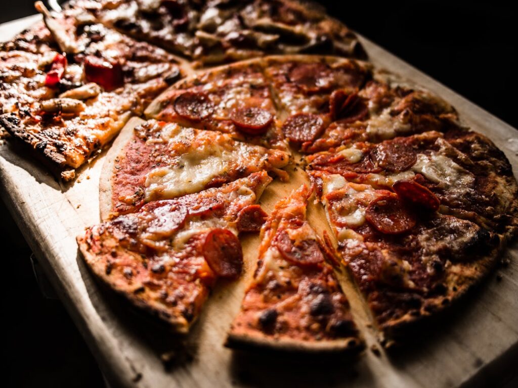 pexels photo 825661 Delicious crispy pepperoni pizza slices on a wooden board, perfect for pizza lovers.